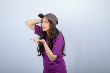 Mor üniformalı teslimatçı kızın portresi üzgün bir suratla duruyor. Yüksek kalite fotoğraf