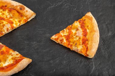 Siyah arka planda sıcak ve lezzetli bir pizza. Yüksek kalite fotoğraf