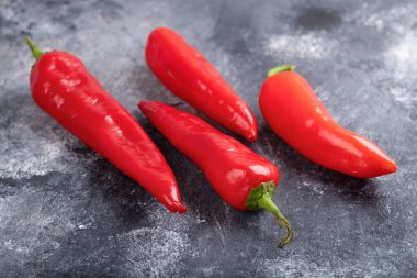 Red fresh chili peppers placed on marble surface. High quality photo