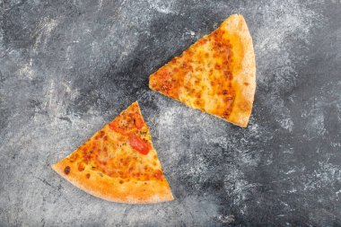 Taş zemine yerleştirilmiş iki dilim lezzetli peynirli pizza. Yüksek kalite fotoğraf