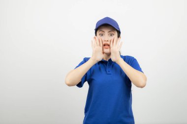 Mavi şapkalı genç bayan kuryenin portresi duruyor ve poz veriyor. Yüksek kalite fotoğraf