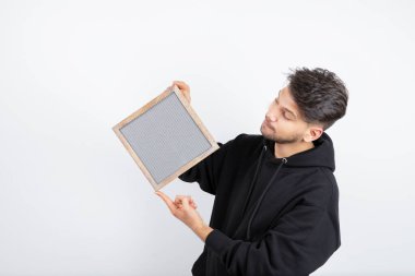 Siyah kapüşonlu genç adam boş çerçeve gösteriyor. Yüksek kalite fotoğraf