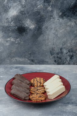 Üzerinde yulaflı kurabiye ve çikolata olan kırmızı bir tabak. Yüksek kalite fotoğraf