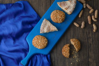 Üzerinde yulaflı kurabiye ve kek parçaları olan mavi tahta bir tahta. Yüksek kalite fotoğraf