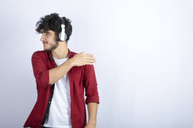 Kulaklıklı bir gencin beyaz arka planda bir yerlere baktığı bir görüntü. Yüksek kalite fotoğraf