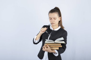 Beyaz arka planda gözlük ve kitap tutan yorgun öğrencinin portresi. Yüksek kalite fotoğraf
