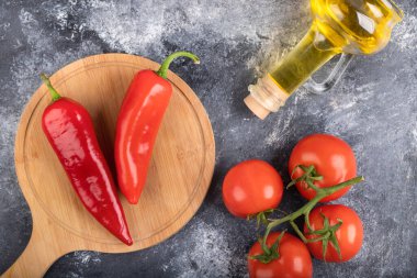 Kırmızı biber, olgun domates ve mermer yüzeyde bir şişe yağ. Yüksek kalite fotoğraf