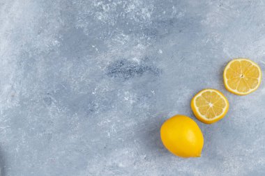 Tam ve dilimlenmiş limon meyveleri taştan bir arka planda. Yüksek kalite fotoğraf