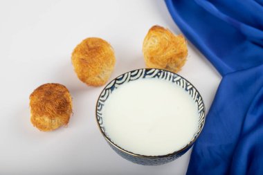 Fresh cool milk in bowl with Turkish desserts . High quality photo