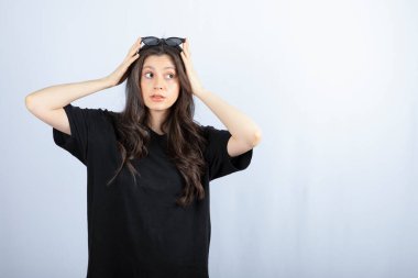 Beyaz arka planda güneş gözlüğüyle poz veren şık bir genç kadın. - Evet. Yüksek kalite fotoğraf