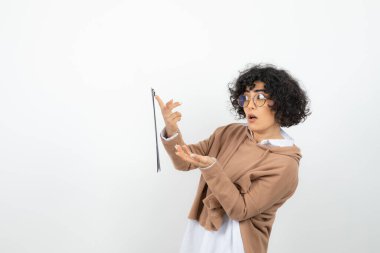 Beyaz arka planda poz veren genç bir kadın