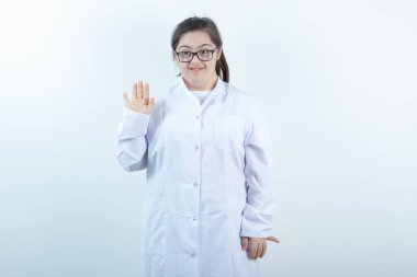 Doktor üniformalı genç bir kız ayakta el sallıyor. Yüksek kalite fotoğraf