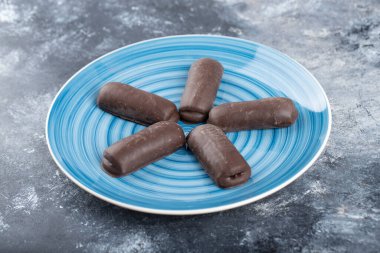 Taştan bir arka plana yerleştirilmiş mavi çikolata tabağı. Yüksek kalite fotoğraf