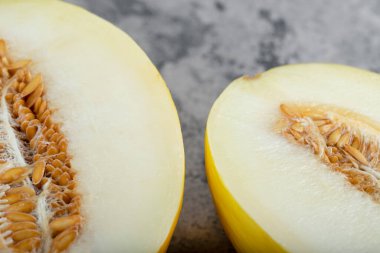 Taş zemine yarım dilimlenmiş sarı kavun yerleştirilmiş. Yüksek kalite fotoğraf