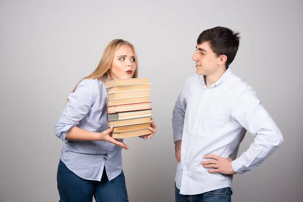Junger Mann Überreicht Seiner Partnerin Ein Buch Auf Grauem Hintergrund — Stockfoto