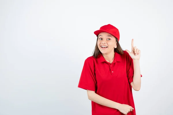 Foto Una Joven Mensajera Uniforme Rojo Señalando Foto Alta Calidad —  Fotos de Stock