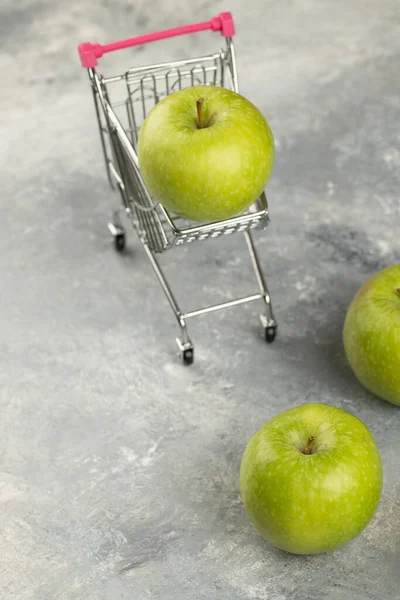 大理石の背景に金属ショッピングカートで緑の新鮮なリンゴ 高品質の写真 — ストック写真