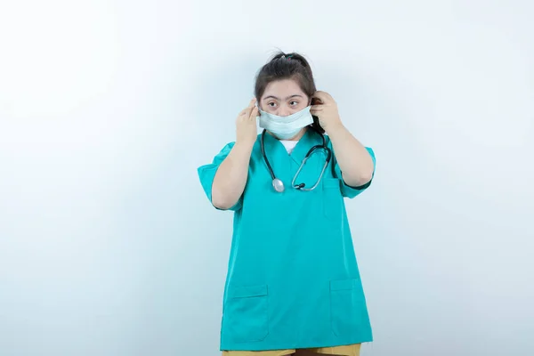 Jonge Vrouwelijke Verpleegster Met Stethoscoop Met Medisch Gezichtsmasker Tegen Witte — Stockfoto