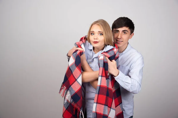 灰色の壁に立っている間 再生毛布で凍結ガールフレンドをカバー若い男 高品質の写真 — ストック写真