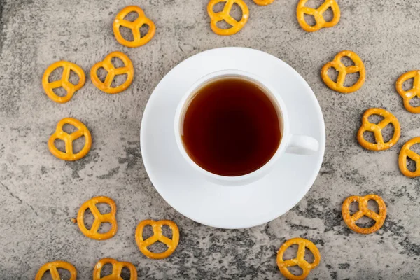 Salzige Cracker Brezeln Mit Einer Tasse Schwarztee Auf Dem Steintisch — Stockfoto