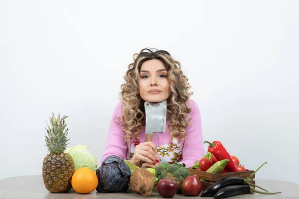 Młoda Kobieta Nożem Przygotowuje Się Cięcia Owoców Siedząc Przy Stole — Zdjęcie stockowe