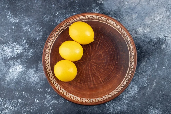 Brown Plate Three Juicy Ripe Lemons Placed Marble Background High — Stok fotoğraf