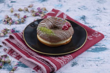 Çikolatalı çörek ve beyaz masada tomurcuklanan güller. Yüksek kalite fotoğraf