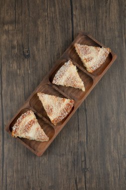 Tahta masa üzerinde hindistan cevizi parçacıkları serpiştirilmiş ahşap pasta dilimleri. Yüksek kalite fotoğraf