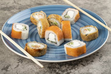 Mavi bir tabak Philadelphia ve sıcak suşi. Masada. Yüksek kalite fotoğraf