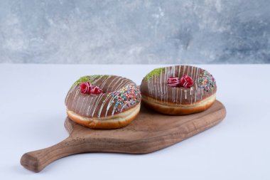 Çikolata kaplamalı çikolatalı donutlardan oluşan tahta bir tahta. Yüksek kalite fotoğraf