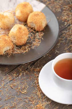 Tahta masaya beyaz bir fincan sıcak çay konmuş Türk tatlıları. Yüksek kalite fotoğraf