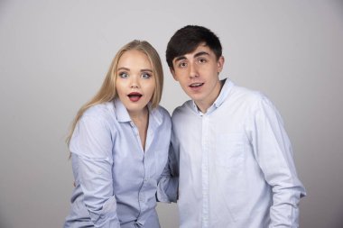 Genç bir çift ayakta durup hayret verici bir şekilde kameraya bakıyor. Yüksek kalite fotoğraf