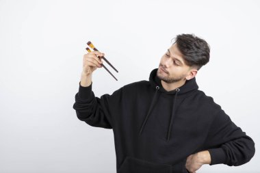 Boyalı fırçalarıyla ayakta duran ve poz veren genç ve yakışıklı bir sanatçı. Yüksek kalite fotoğraf