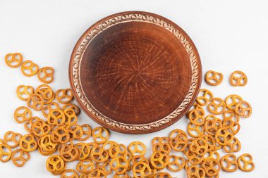 Beyaz arka plana yerleştirilmiş kahverengi tuzlu kraker tabağı. Yüksek kalite fotoğraf