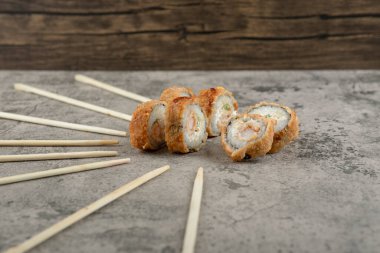 Kızarmış suşi, yemek çubukları ve arka planda defter. Yüksek kalite fotoğraf