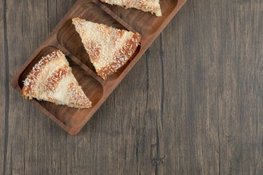 Tahta masa üzerinde hindistan cevizi parçacıkları serpiştirilmiş ahşap pasta dilimleri. Yüksek kalite fotoğraf