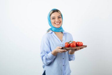 Elinde ahşap domates tahtası olan mendilli güzel bir kadın resmi. Yüksek kalite fotoğraf