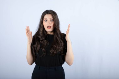 Beyaz arka plandaki bir şeye şaşıran uzun saçlı bir kızın görüntüsü. Yüksek kalite fotoğraf