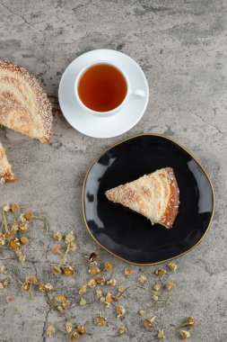 Taş zeminde bir fincan sıcak çayla nefis vanilyalı kek. Yüksek kalite fotoğraf