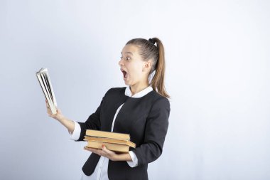 Beyaz arka plan üzerine kitap okuyan bir kız öğrencinin resmi. Yüksek kalite fotoğraf