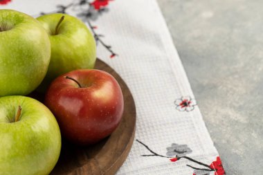 Tahta tabağa yerleştirilmiş kırmızı ve yeşil taze elma. Yüksek kalite fotoğraf