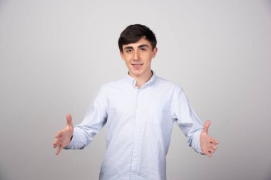  Gri duvarda elleri olan genç ve güzel bir adamın portresi. Yüksek kalite fotoğraf