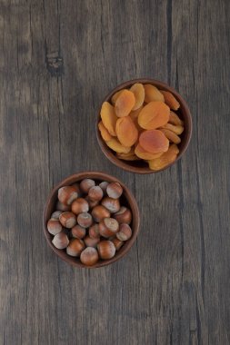 Sağlıklı fındıklı kurutulmuş kayısı meyveleriyle dolu ahşap bir kase. Yüksek kalite fotoğraf