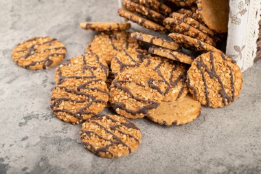 Bir sepet yulaf ezmeli kurabiye ve taşın üstünde çikolata. Yüksek kalite fotoğraf