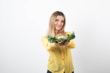 Gülümseyen güzel bir kadın modelin elinde karnabahar tutarken fotoğrafı. Yüksek kalite fotoğraf