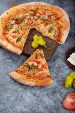 Taş bir masanın üzerine dilimlenmiş lezzetli pizza. Yüksek kalite fotoğraf