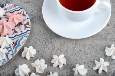 Renkli tatlı kremalı şekerler ve arka planda bir fincan çay. Yüksek kalite fotoğraf