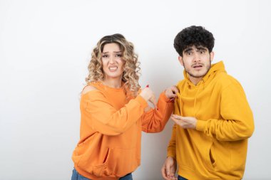 Genç bir kadın kapüşonlu esmer adama dokunuyor. Yüksek kalite fotoğraf