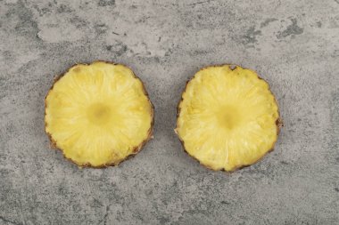 Taş zemine iki dilim lezzetli ananas yerleştirilmiş. Yüksek kalite fotoğraf