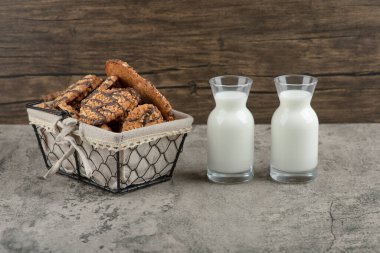 Sepetinde çikolata jöleli leziz çoklu tahıllı kurabiyeler ve iki bardak süt kavanozu. Yüksek kalite fotoğraf